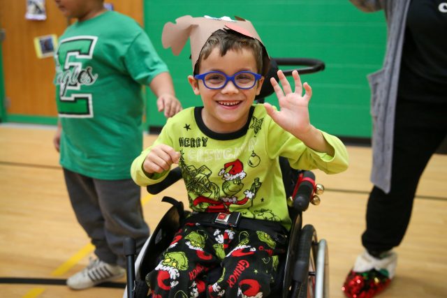 student waves at camera