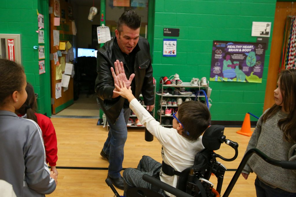 Musician gives high 5 to student