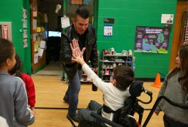 Musician gives high 5 to student