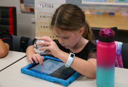 Young student holding Sphero bot