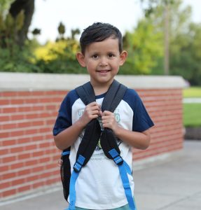 Young male elementary student with backpack