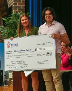 Jen Smoker awarding Grissom Scholarship to an 8th grade student (2023)