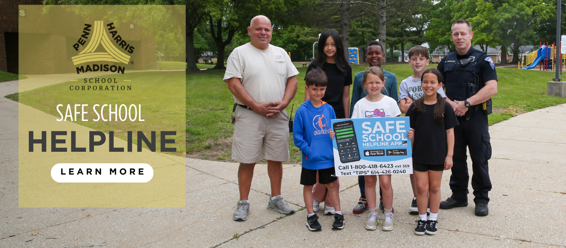 People posing in front of a sign that says "safe school helpline" and includes a phone number.